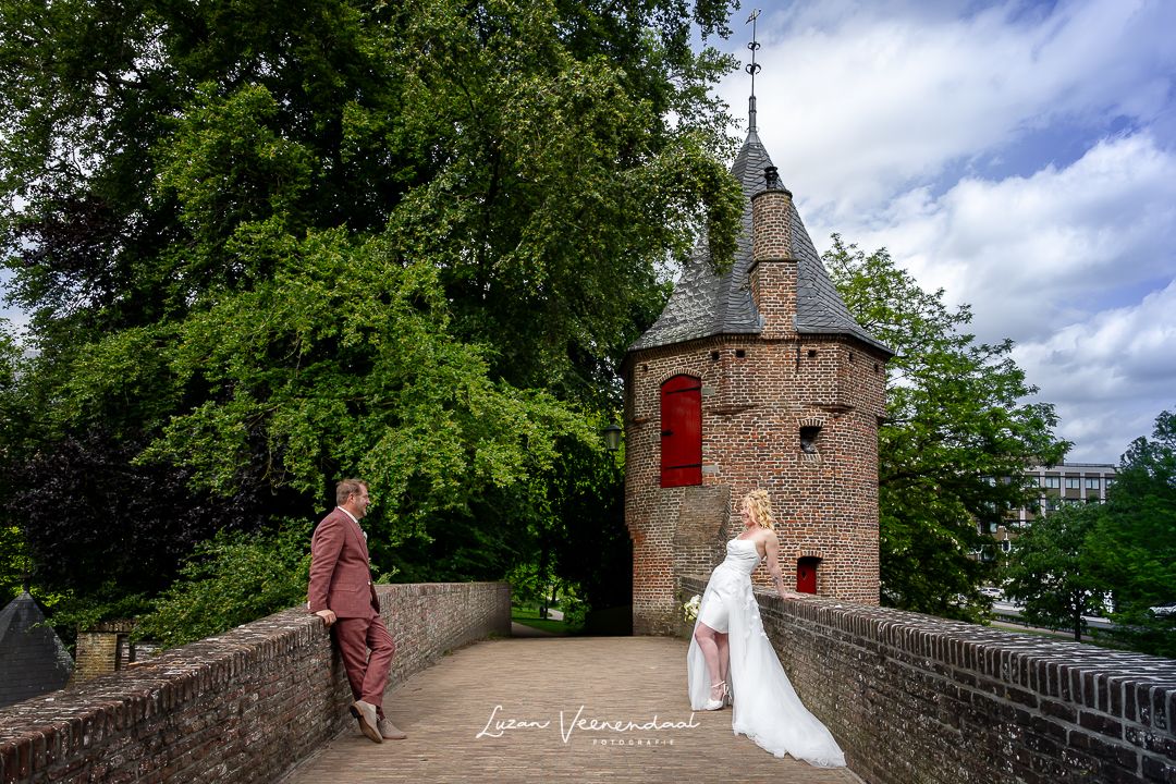 Bruidspaar tijdens fotoshoot bij de historische waterpoort Monnikendam in Amersfoort