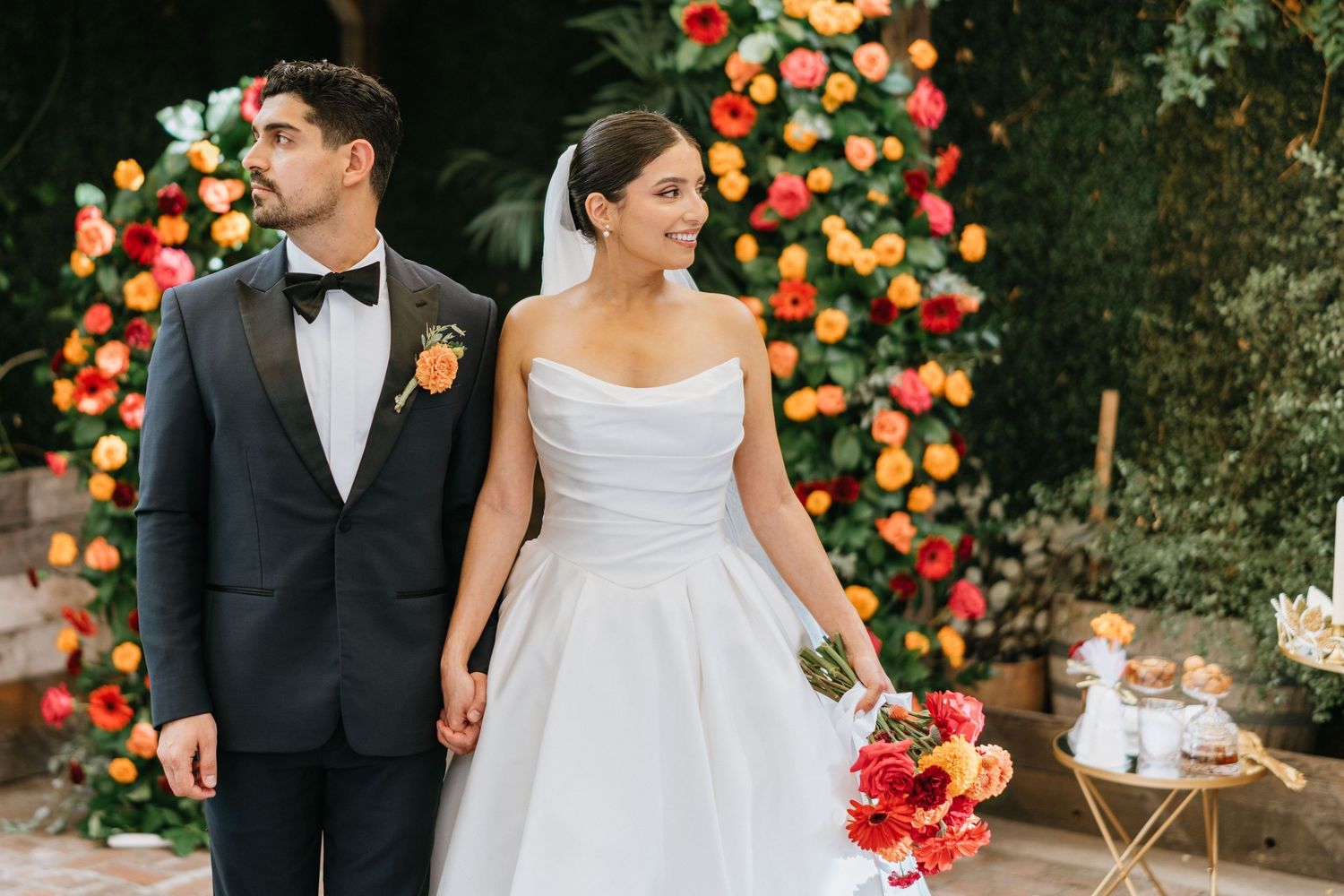 Ruby and Sina holding hands during romantic wedding portraits in the garden courtyard.