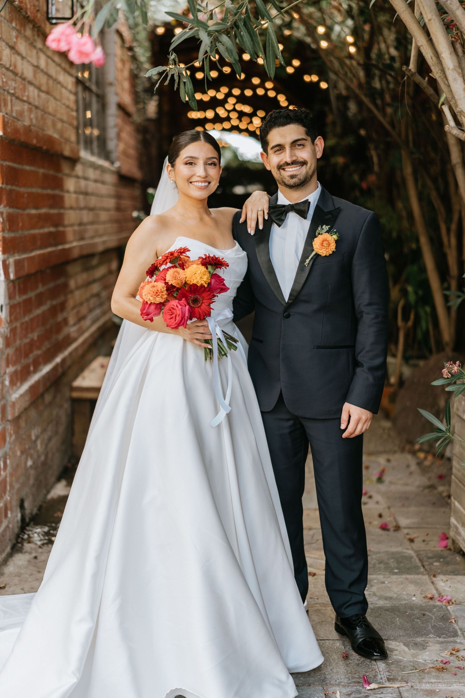 Full-length portrait of Ruby and Sina together after their outdoor wedding ceremony.