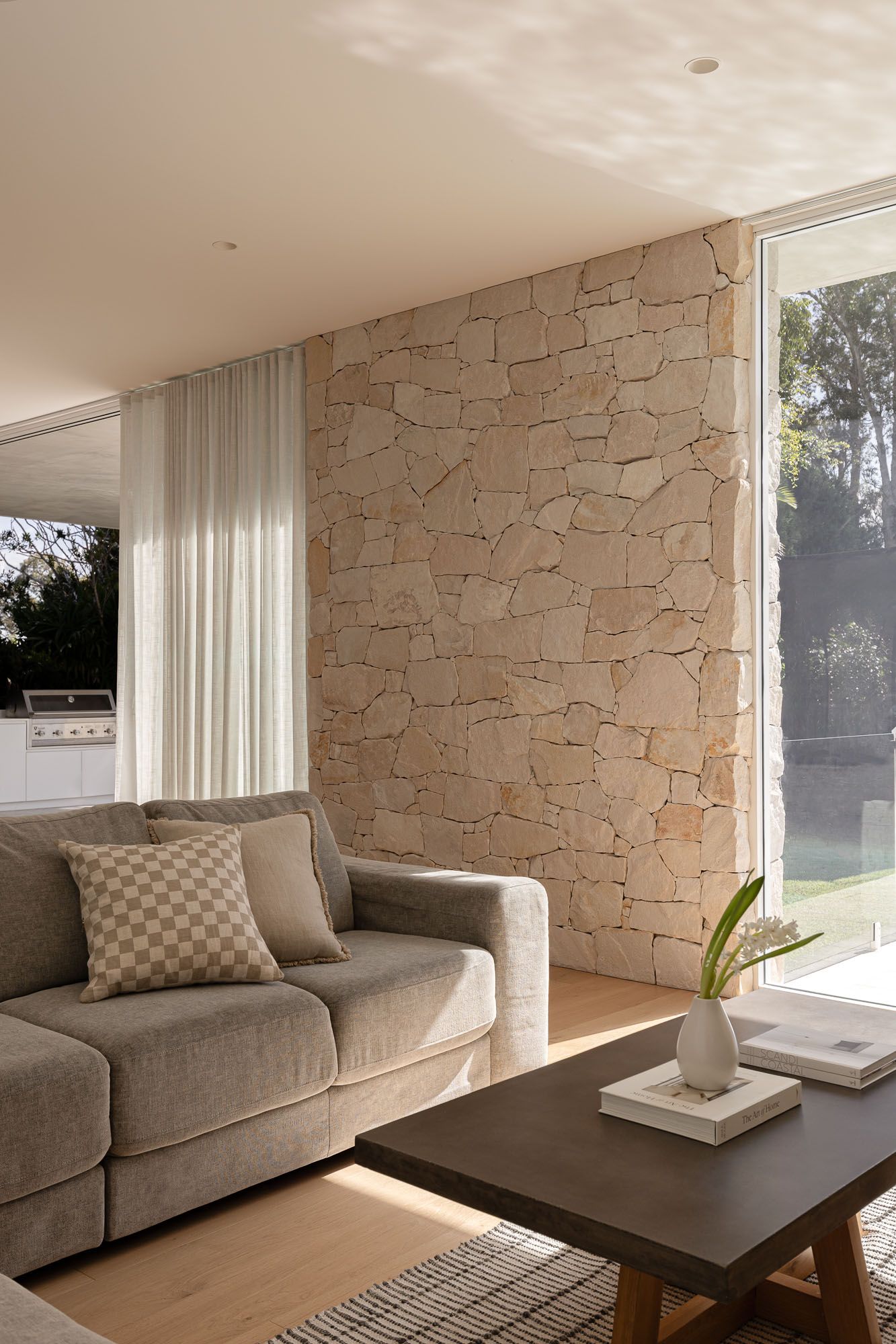 Interior photography of a living space with natural stone accent wall captured in Port Hacking, Sutherland Shire NSW.