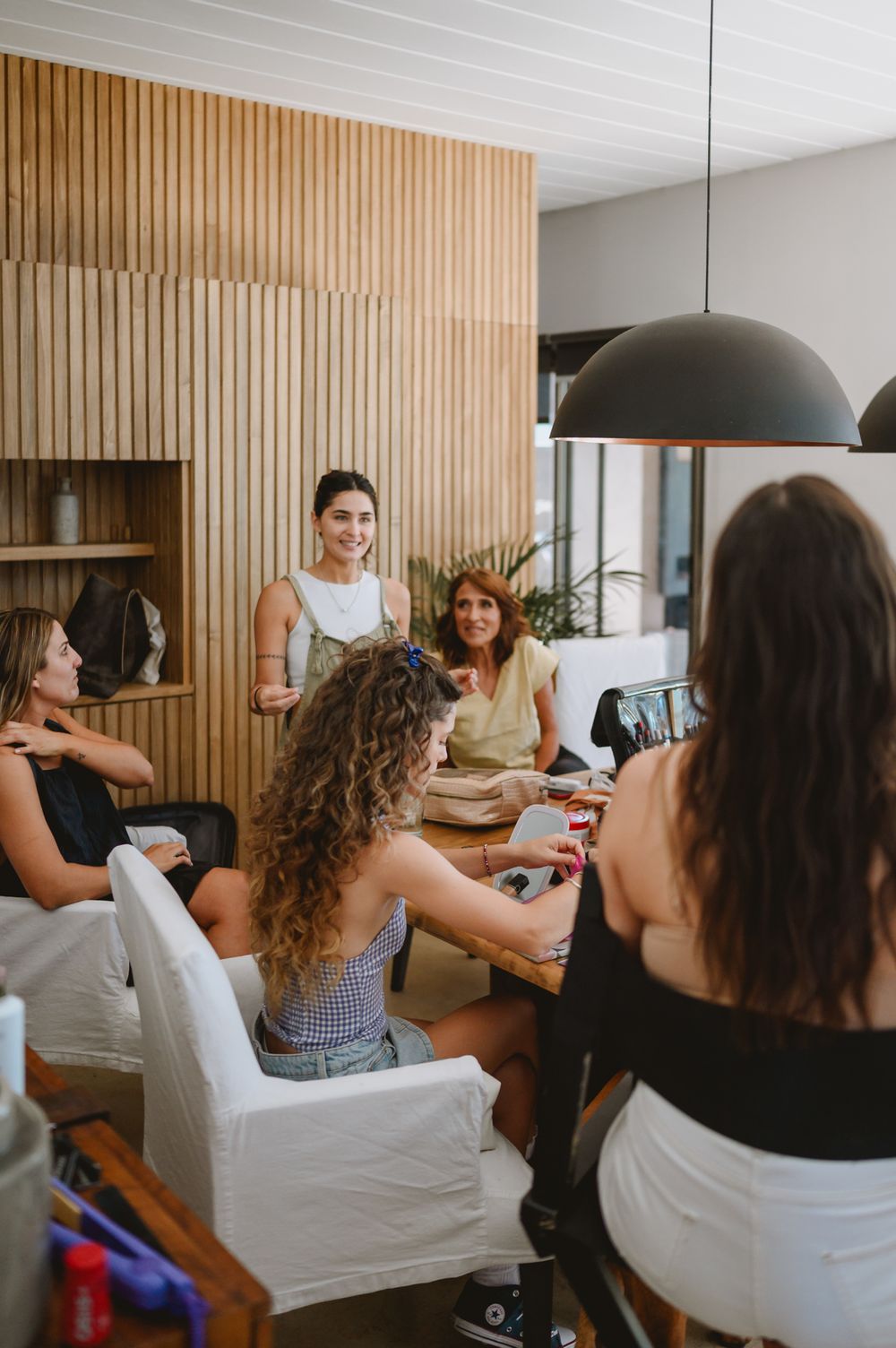 Group of women gathered around a table during bridal party wedding preparations.