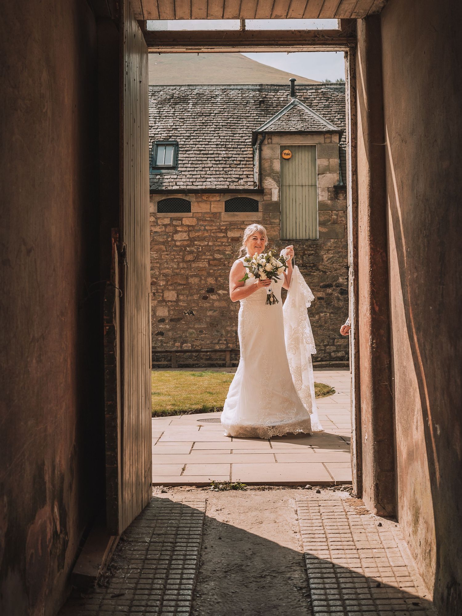 Bride framed by a doorway at Falkland Estate, Fife, before her intimate Scotland wedding.