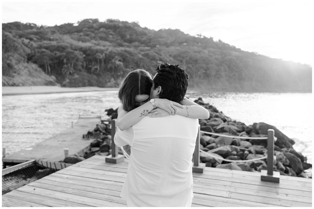 One and Only Mandarina photographer capturing a couple embracing on a dock during a One and Only Mandarina photoshoot.