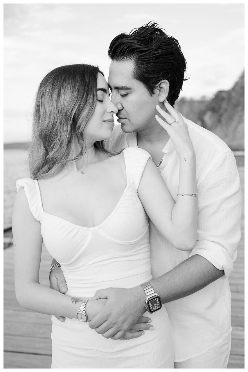 Sayulita engagement photographer capturing a couple in a close intimate moment on a pier with engagement photos Punta Mita.