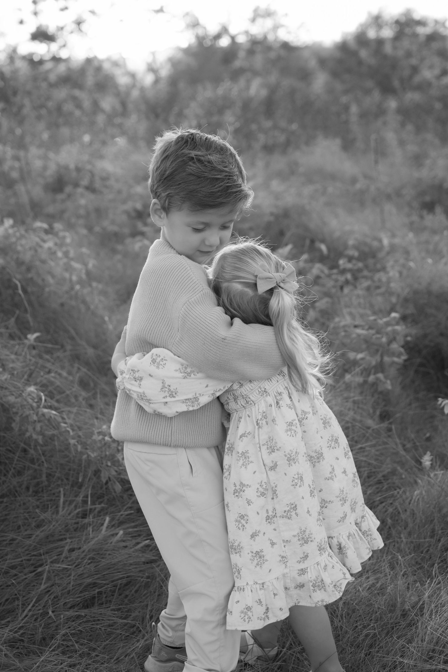 young brother and sister hugging in the sunlit fields of hudson wisconsin during a fall mini session with Jagger Rose Photography