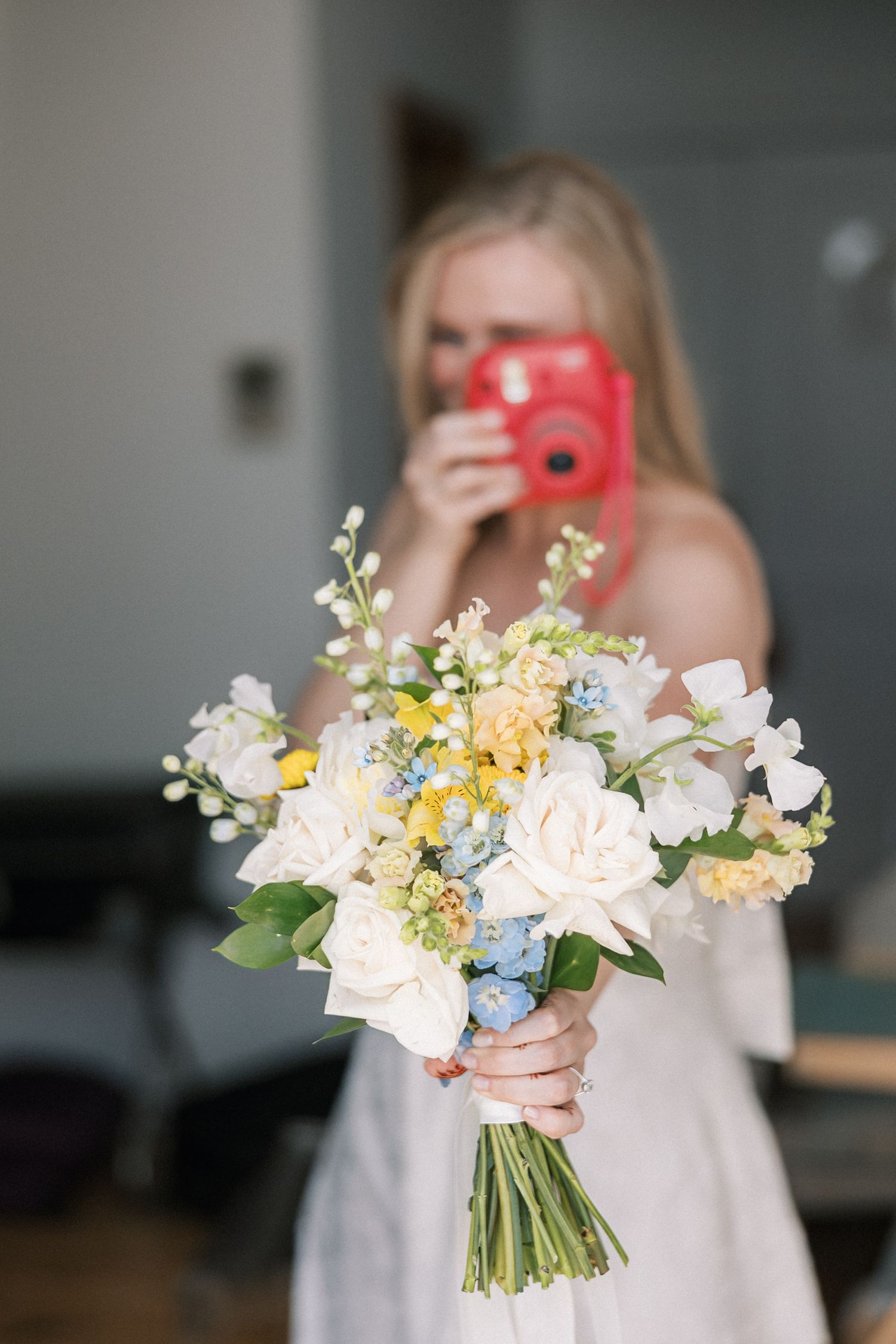 Bride holding a colourful wedding bouquet while getting ready at Farol Hotel before her oceanfront wedding in Cascais.