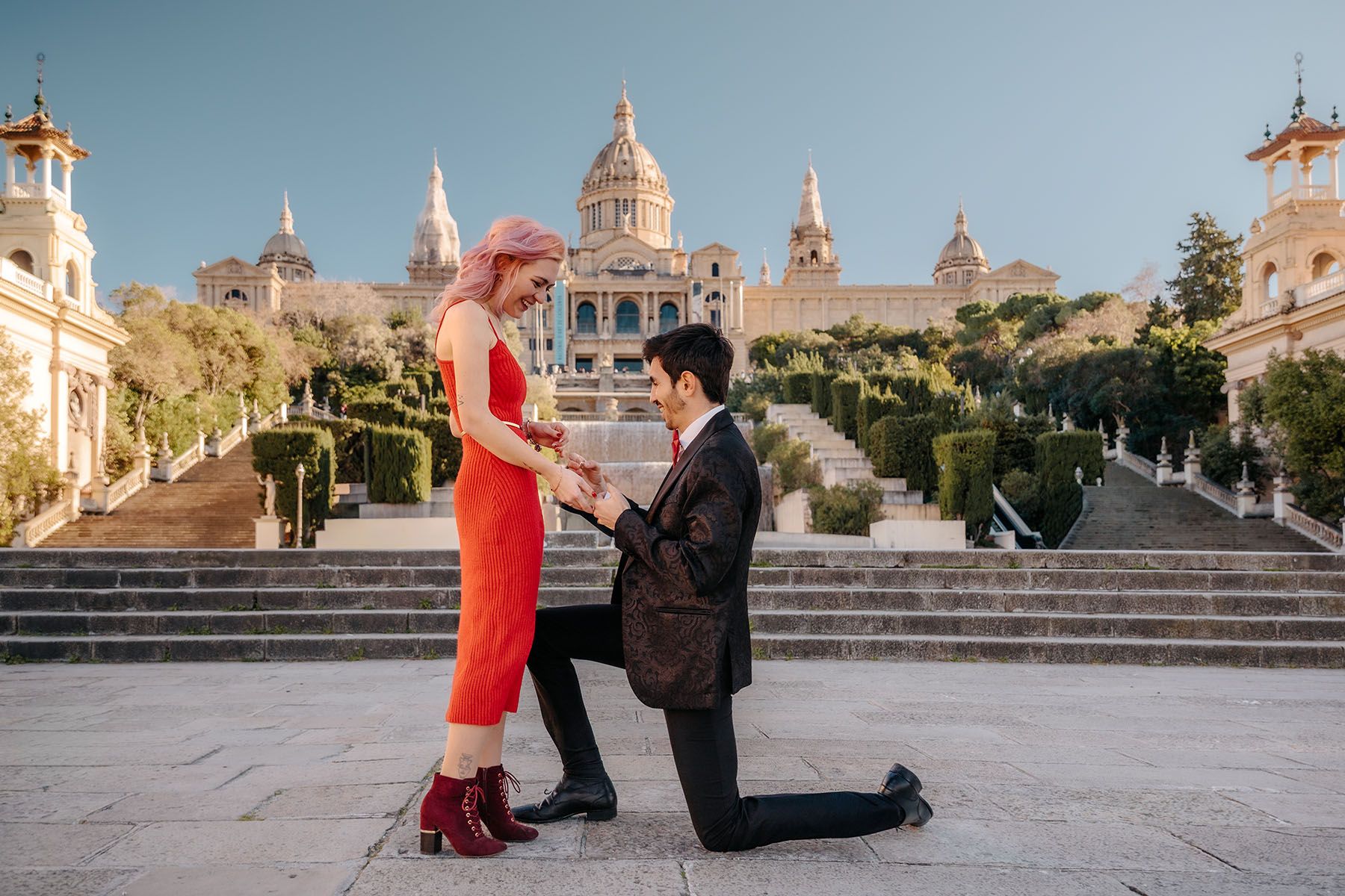 Happy couple kissing after a proposal at the classic, symmetrical selfie viewpoint of the MNAC.