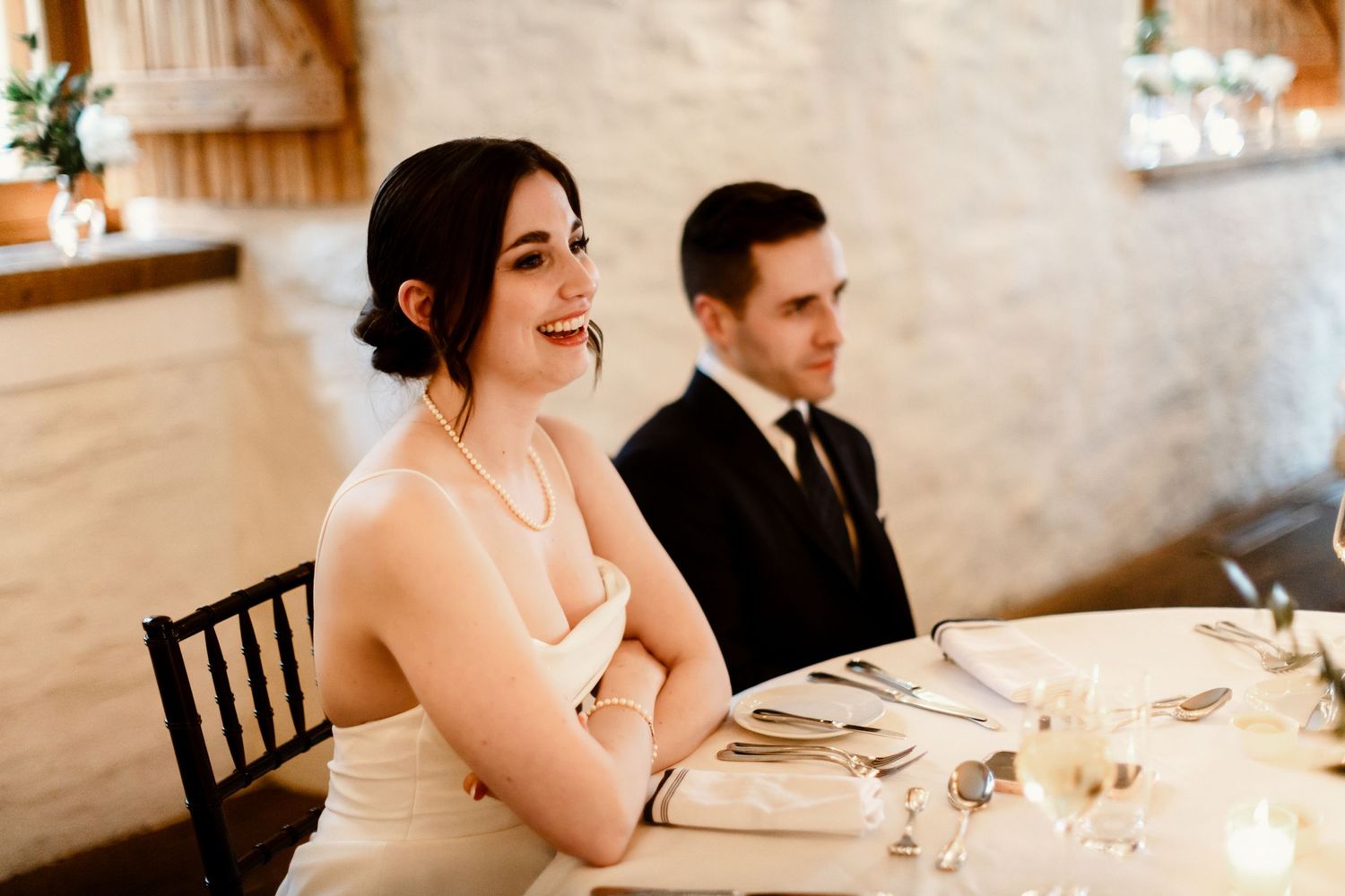 Wedding reception table setting with elegant decor in a rustic venue.