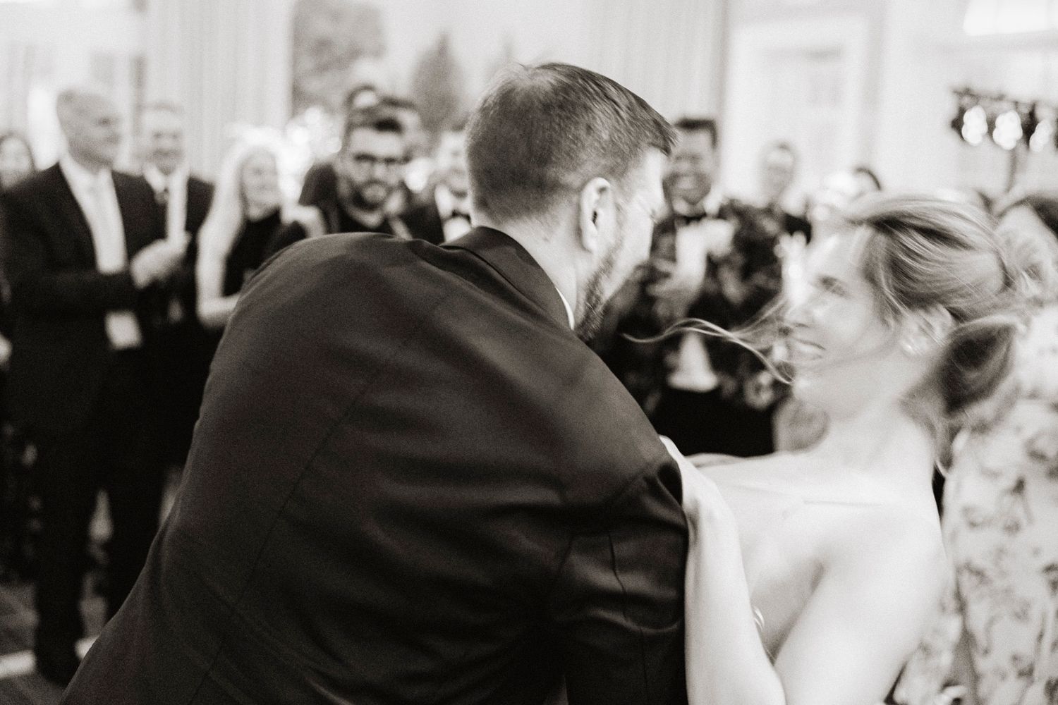 Black and white photo of a couple sharing a dance during their wedding celebration.