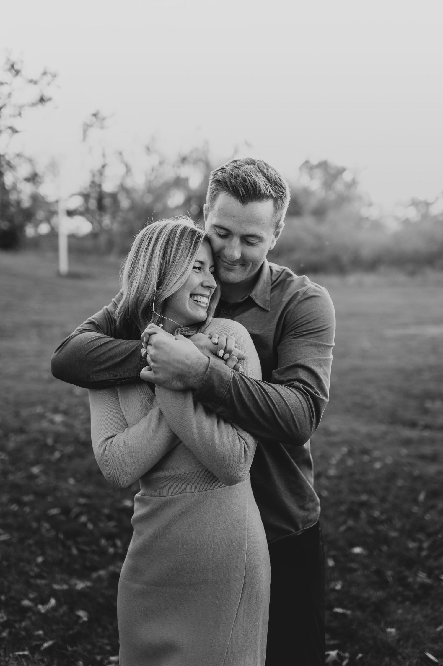 Intimate black and white portrait of couple embracing outdoors.