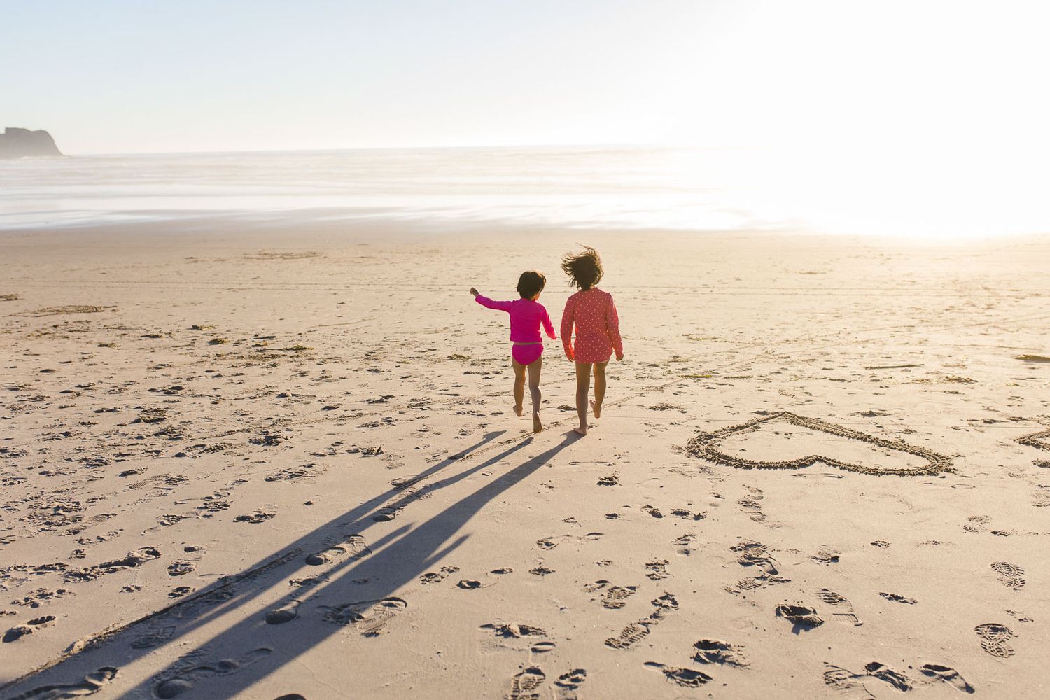 Ellie and JoJo walking on a beach at the Oregon Coast