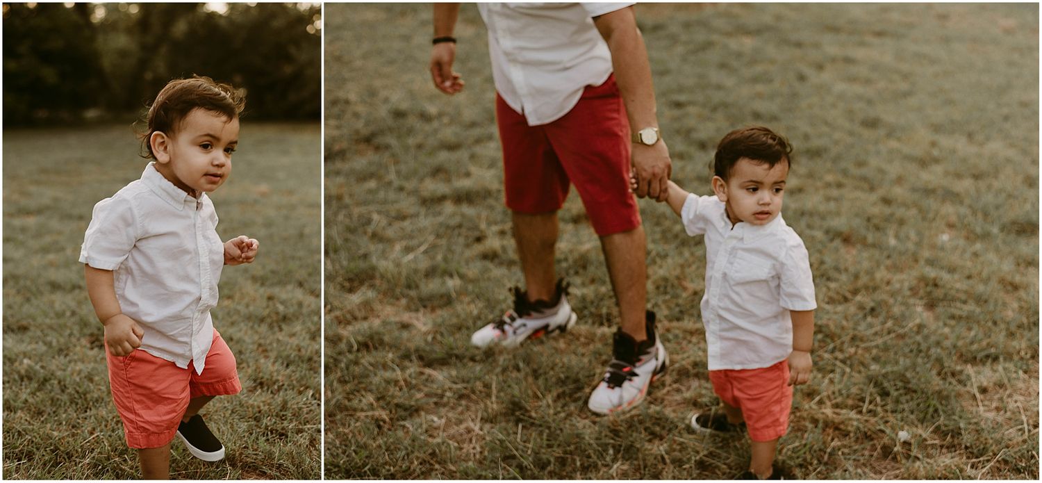 Children in matching white shirts and red shorts play on grassy field at sunset.