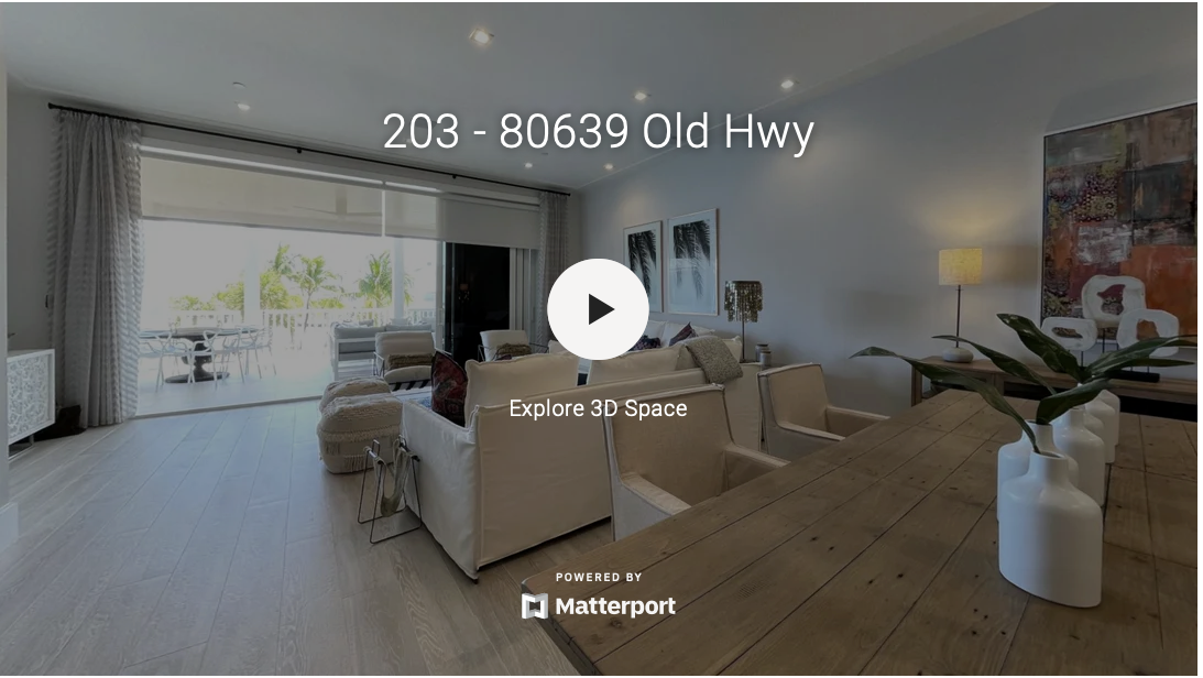 Bright coastal-style living room with white furniture and large sliding doors.