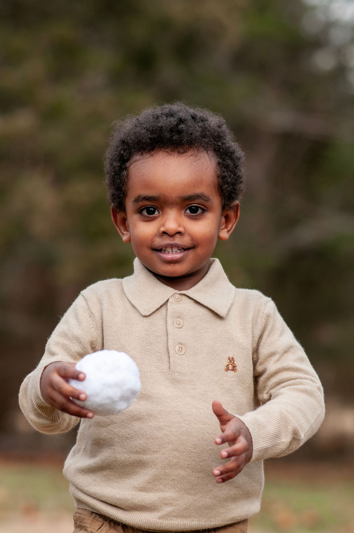 Two year old holding snowball outdoor photo
