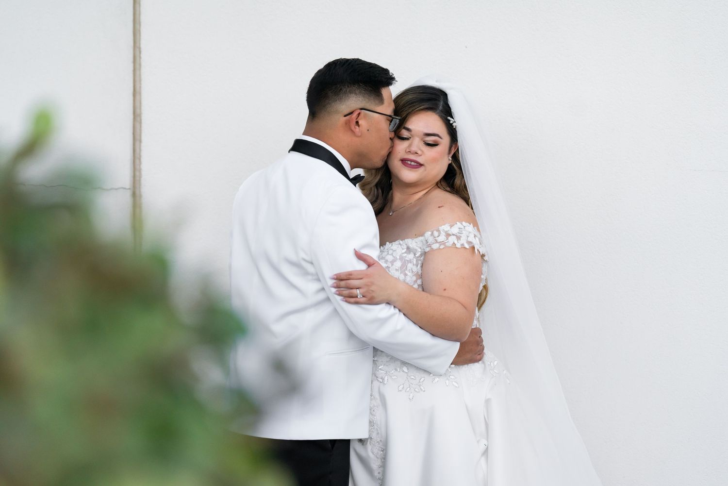 Intimate wedding portrait featuring a romantic embrace against a soft blurred background.