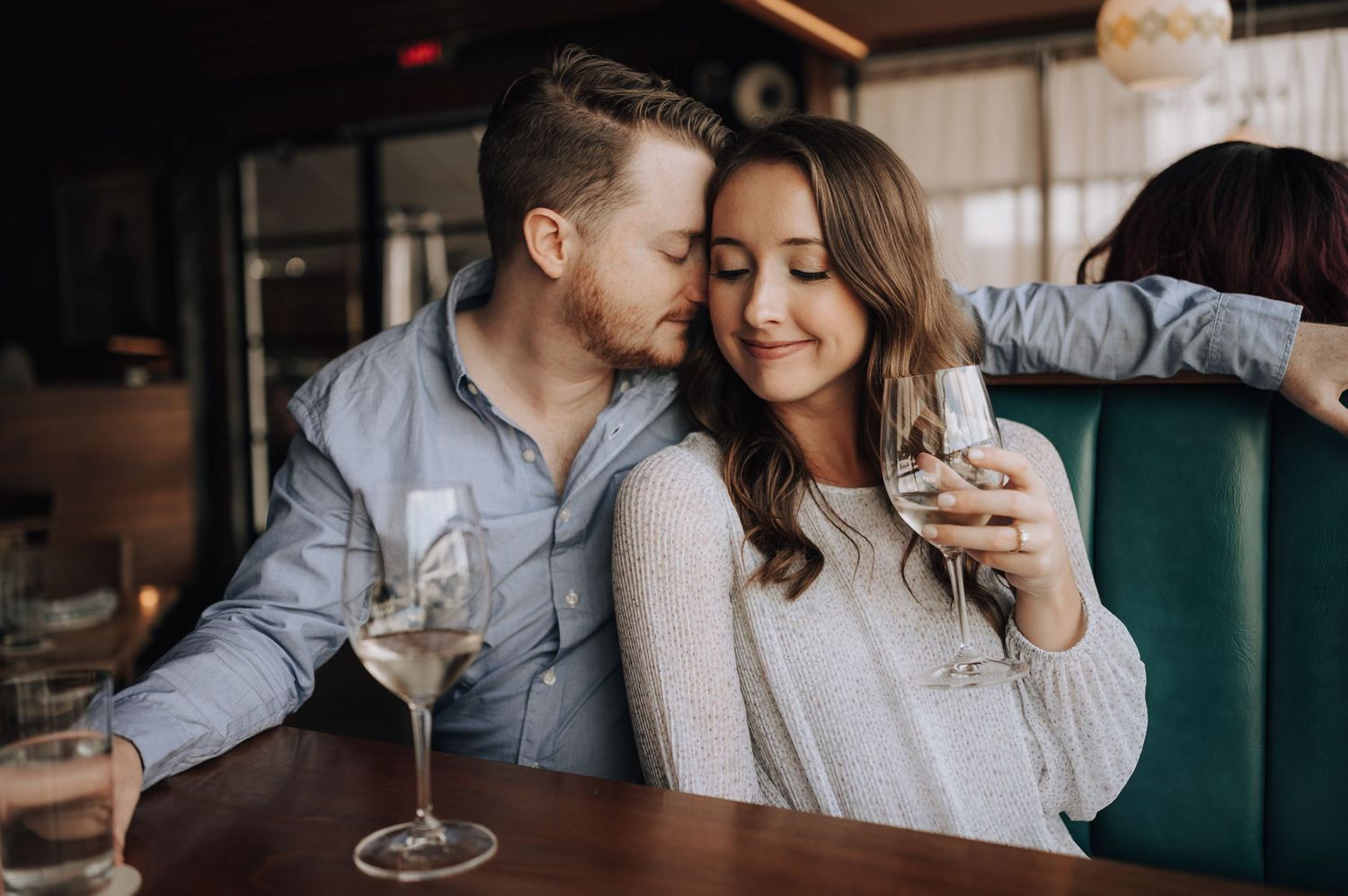 Intimate restaurant scene with couple sharing wine and romantic moment.