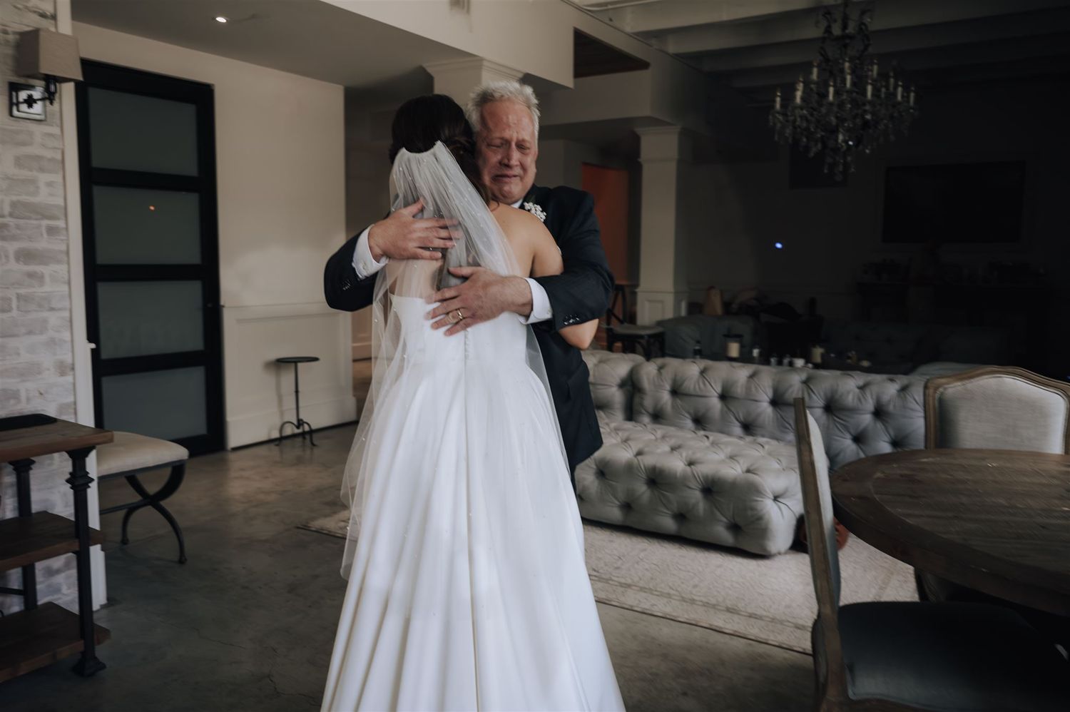 Emotional wedding moment shared in modern industrial venue with elegant decor.