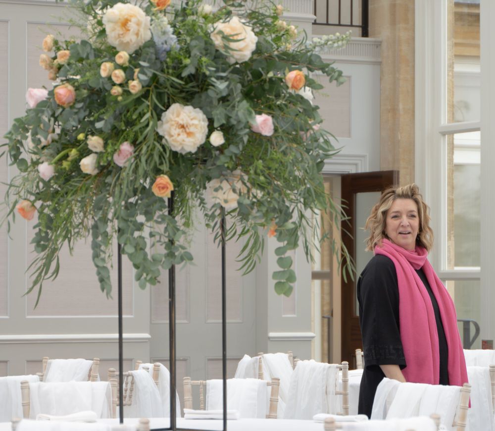 Elegant table settings with lush floral centerpieces featuring peach and cream blooms.