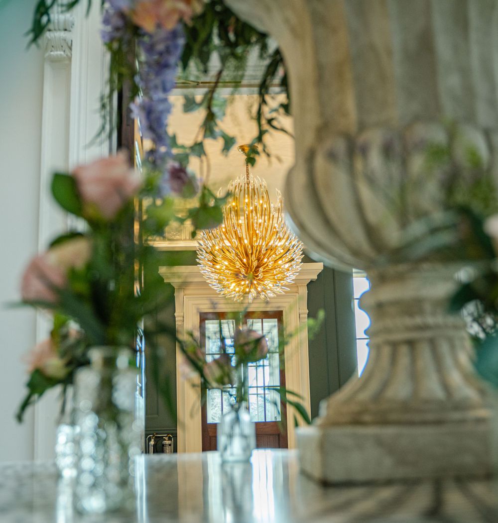 Crystal chandelier and floral arrangements create an elegant atmosphere in a formal setting.