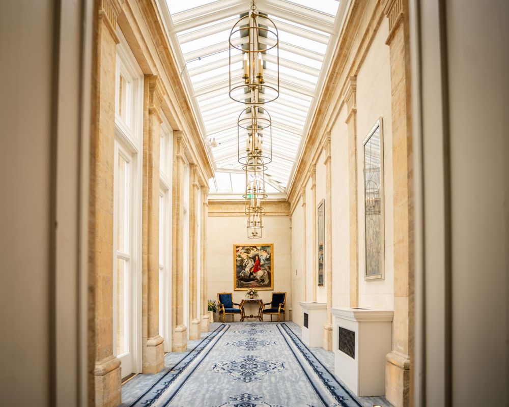 Elegant hallway with skylight and ornate architectural details in a historic building interior.