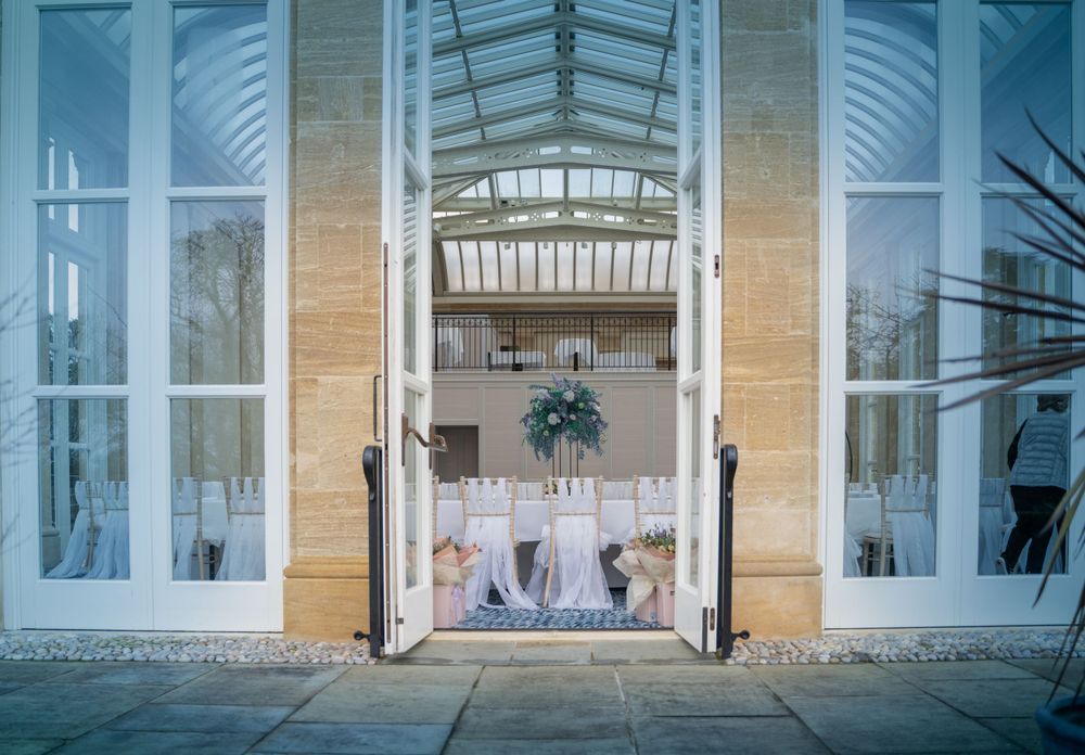 Modern conservatory-style windows with white frames and glass panels in a formal setting.