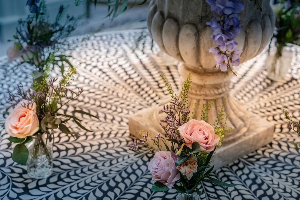 Delicate floral arrangements with pink roses and purple flowers creating intricate shadow patterns.