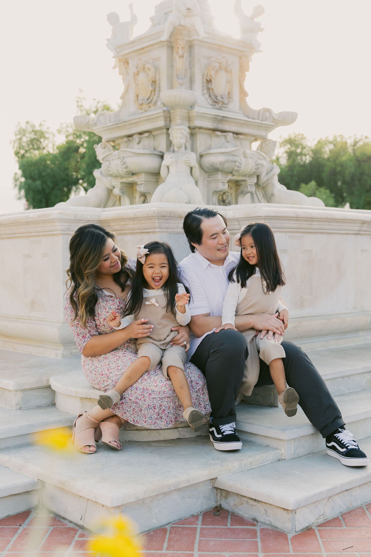 Family members sit and play together on grand architectural stone steps.