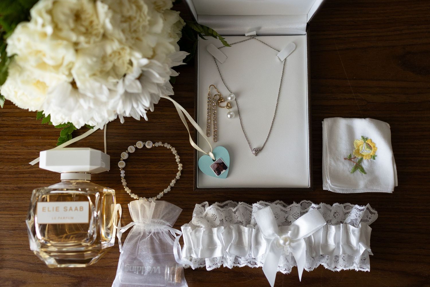 Wedding details including flowers, perfume, necklace and bracelets