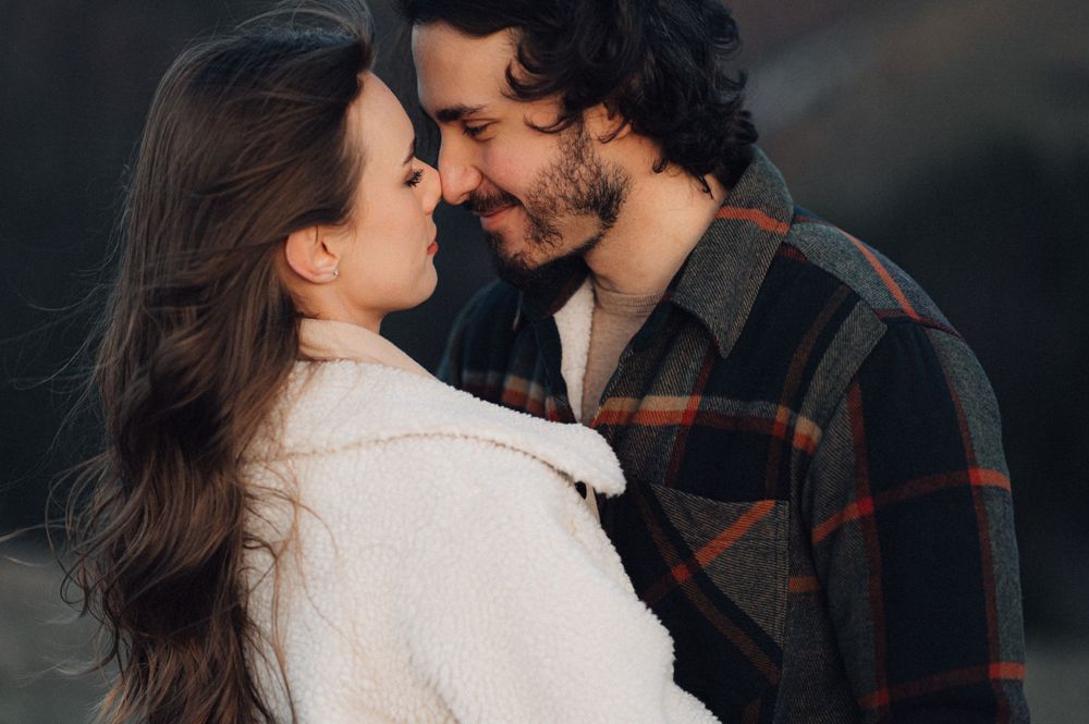 A tender moment shared between two people wearing contrasting winter attire.