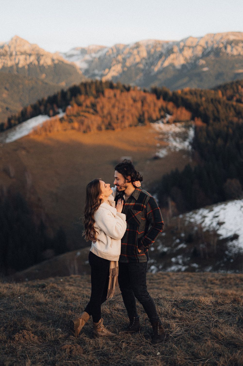 A romantic moment captured against dramatic mountain scenery during golden hour.