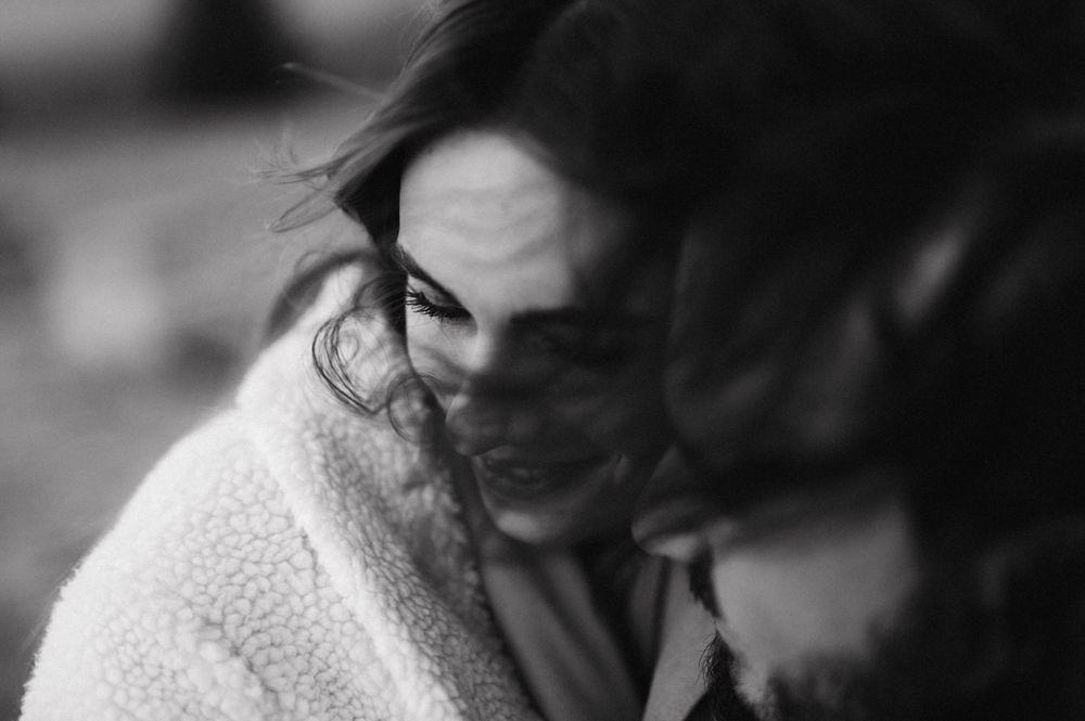 Intimate black and white portrait of couple sharing tender moment.