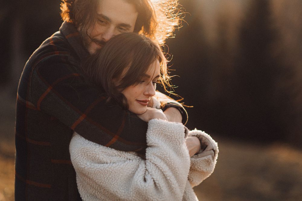 Intimate embrace captured in warm sunset light during winter season.
