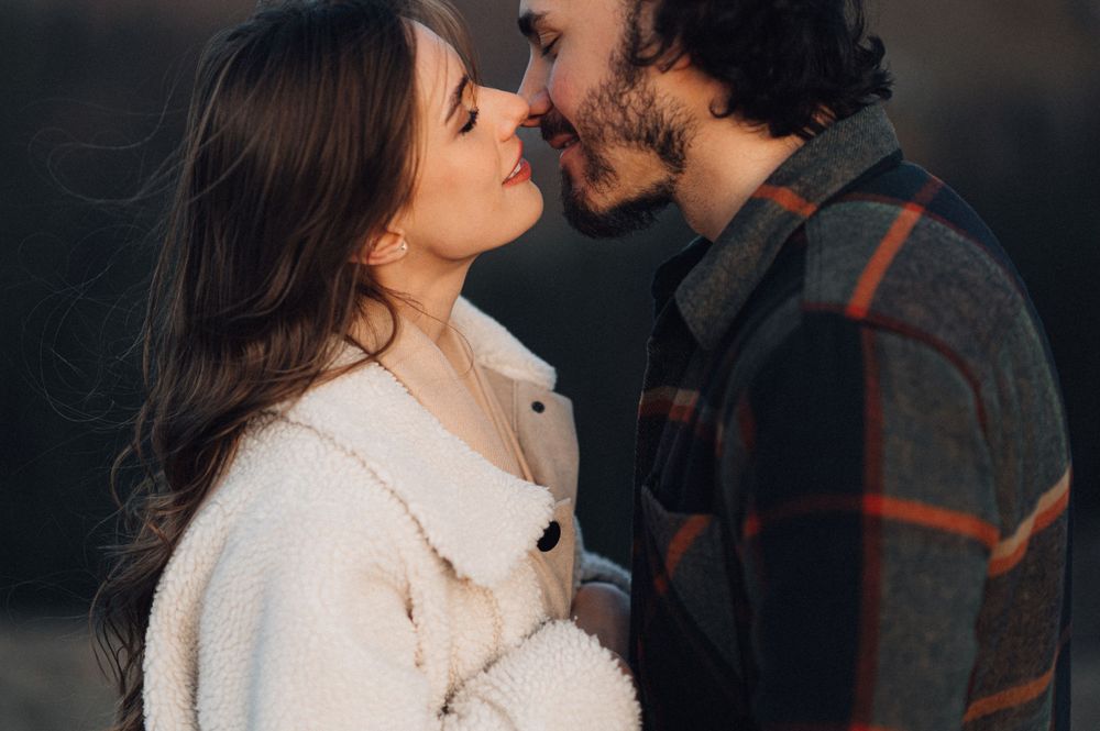 A gentle moment between two people with mountain peaks glowing in evening light.