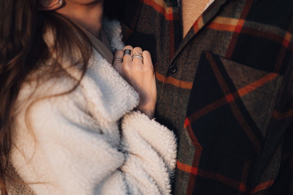 Close-up shot of a cozy winter embrace against a plaid pattern background.