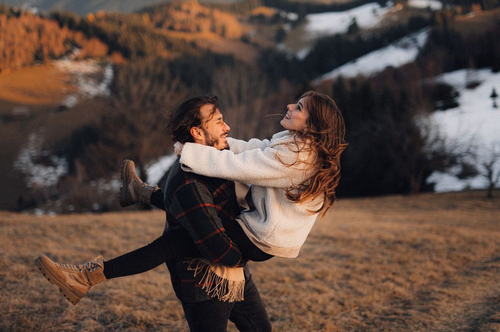 A romantic spin on a hillside with mountains and snow in the background.