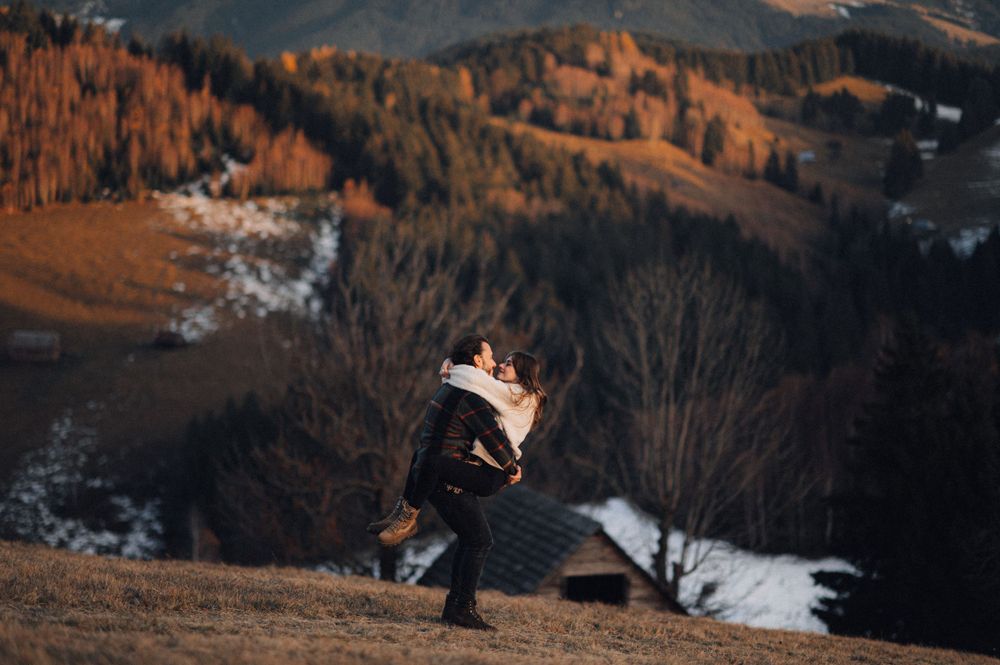 A playful lift in front of a scenic mountain landscape with patches of snow.