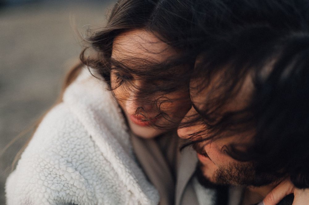 Close up of couple sharing tender moment in warm natural light.