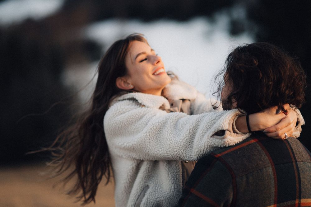 A joyful embrace captured against a winter mountain backdrop.