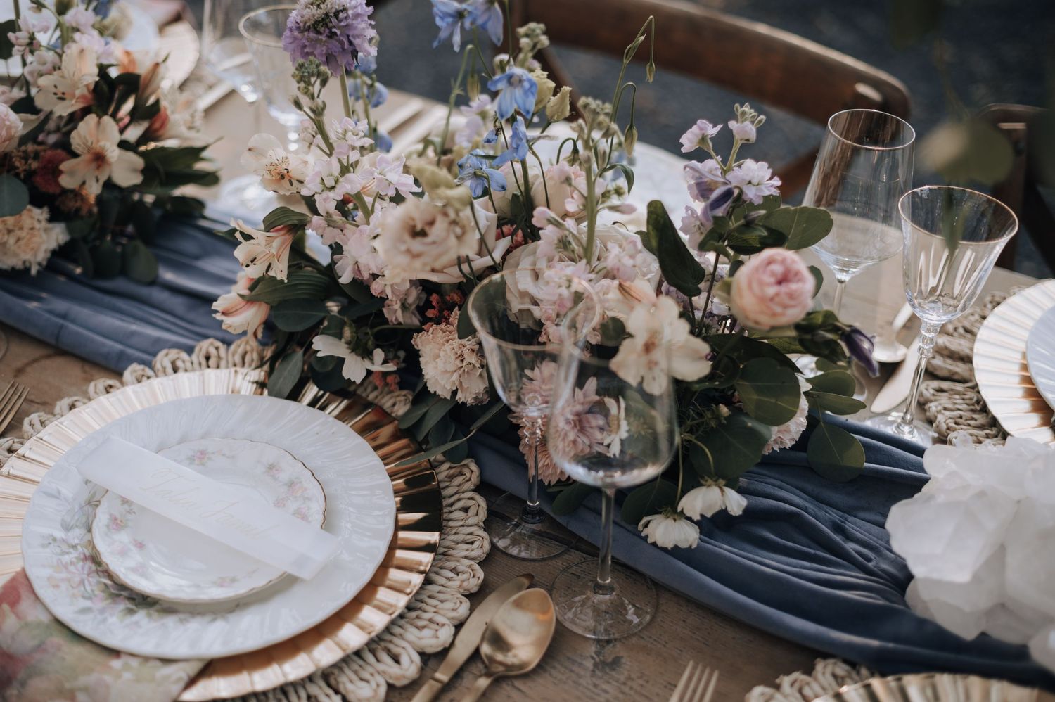 Elegant table setting with pink flowers and navy linens for a wedding reception.