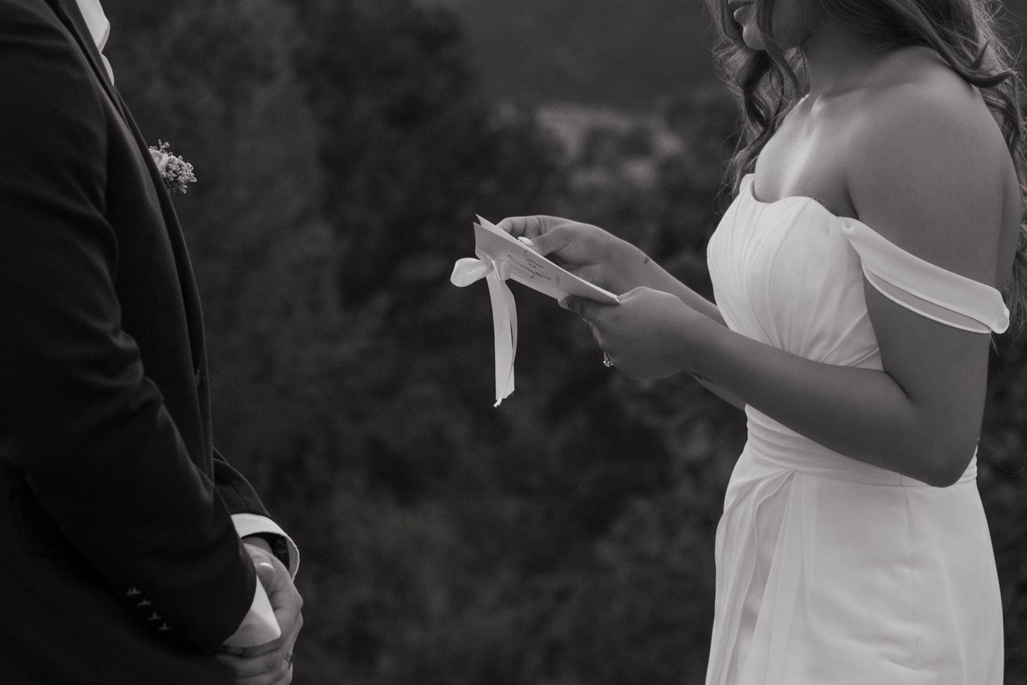 Black and white photo of a bride reading wedding vows during outdoor ceremony. Colorado Garden of the Gods