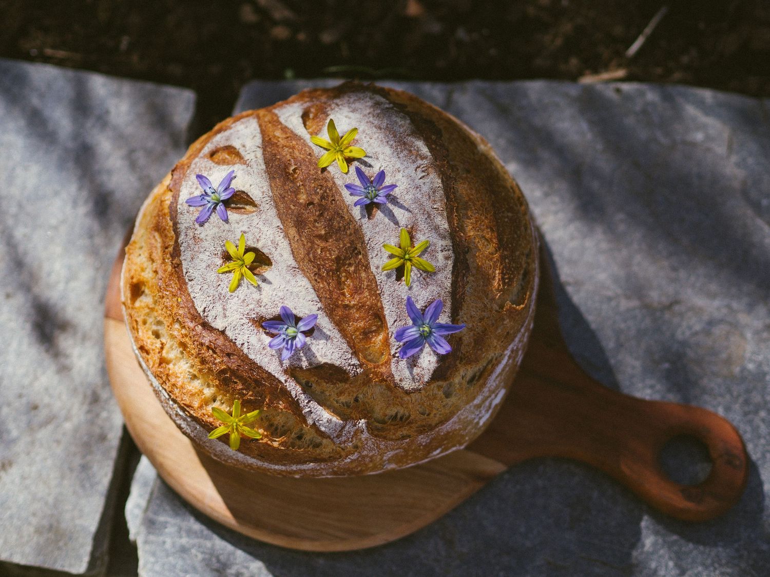 Hjemmebakt surdeigsbrød pyntet med spiselige blomster.