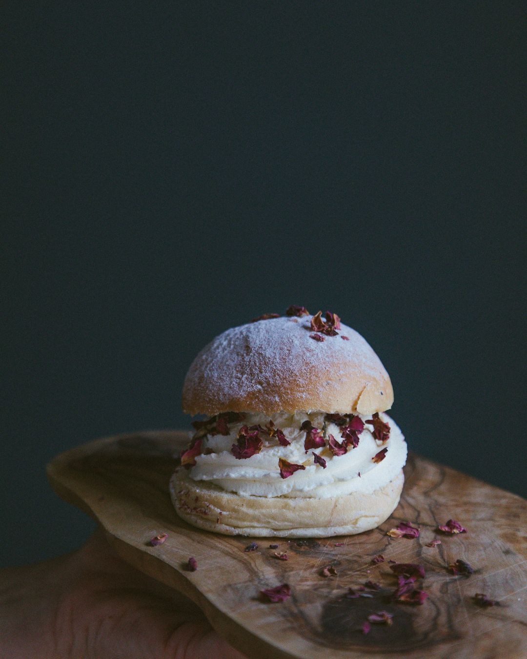 Nærbilde av svensk fastelavensbolle med spiselige blomster, også kjent som semla.