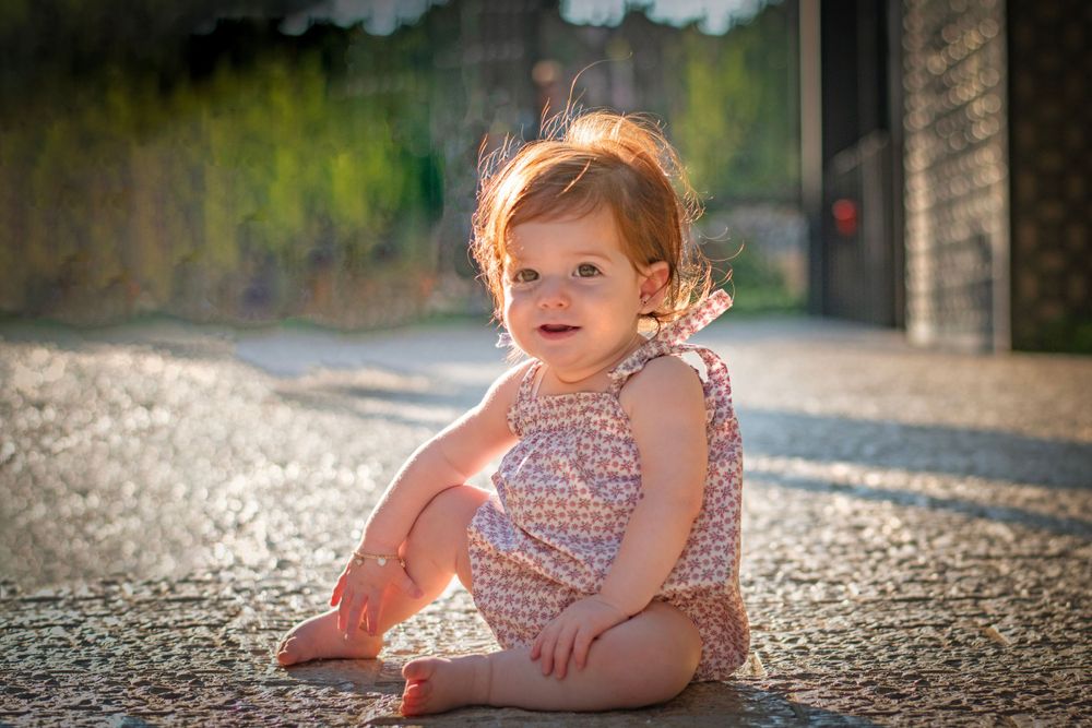 A baby girl happily posing in the magical Jerusalem Estates Garden, Jerusalem.