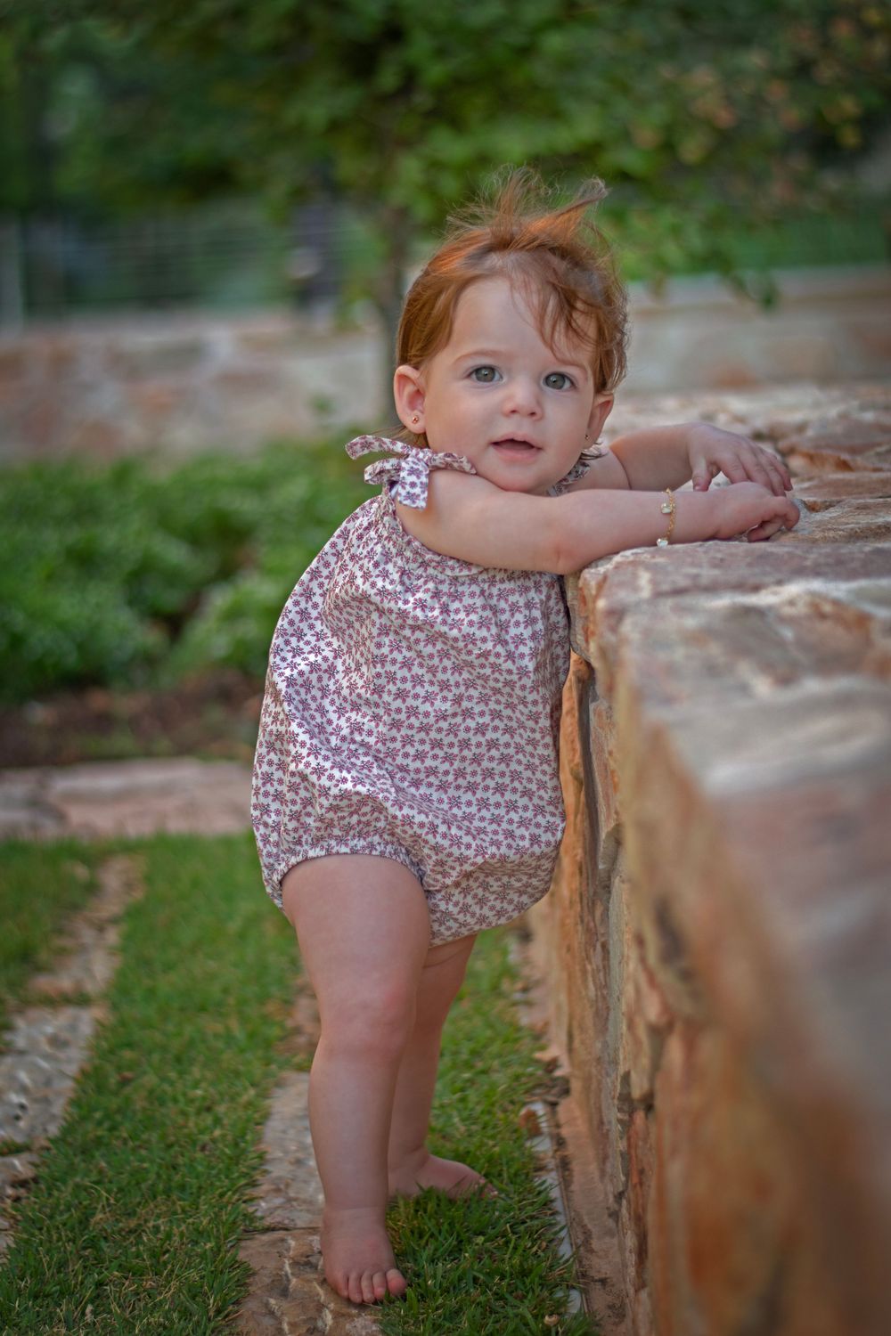 A baby girl happily posing in the magical Jerusalem Estates Garden, Jerusalem.