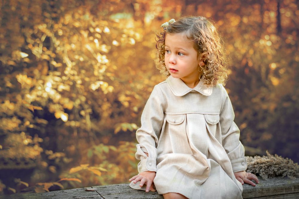A young girl sitting on a bridge in Lake Shanendoah during sunset