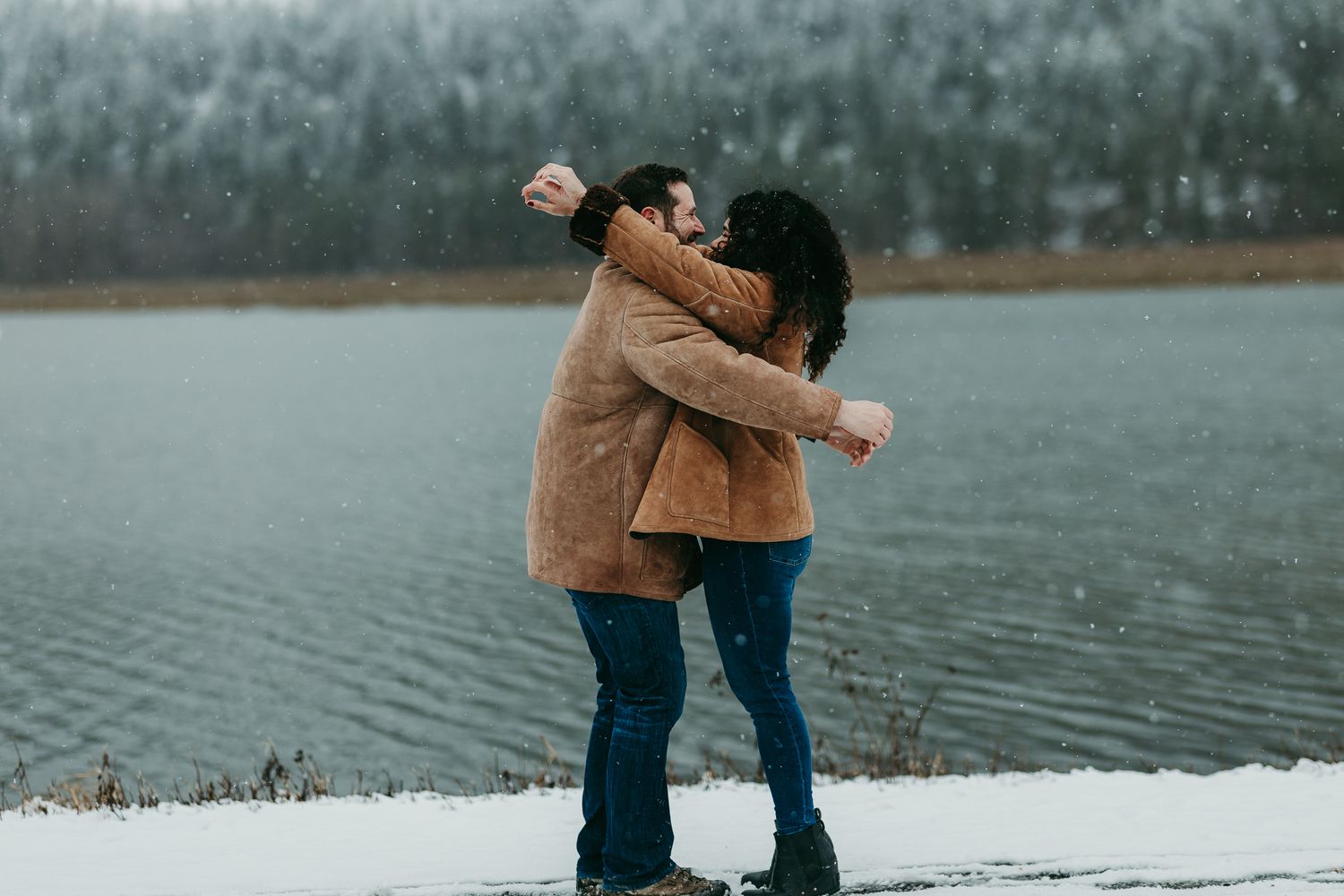 Couple embracing beside a wintry lake
