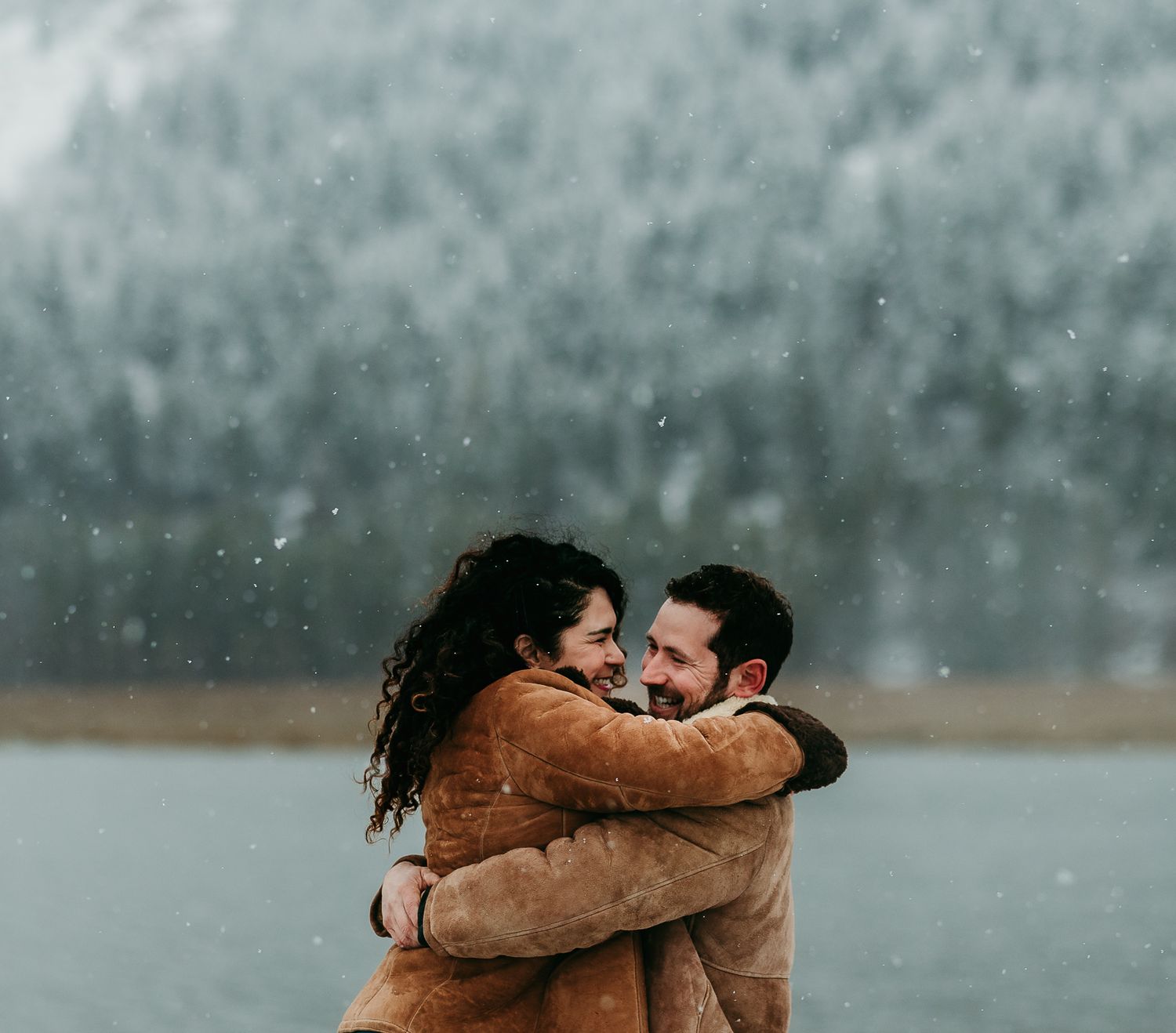 Man and woman hugging by a frozen lake