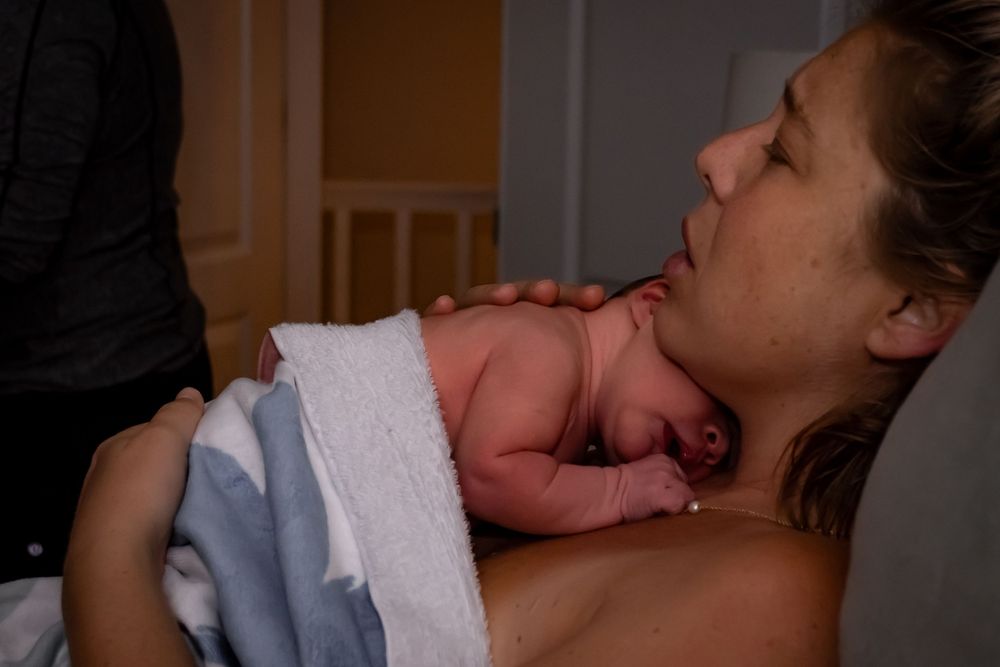 Newborn baby experiencing first skin-to-skin contact moments after birth.