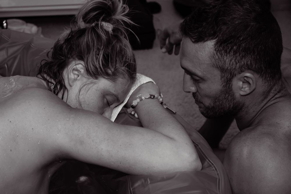 Intimate black and white photo capturing emotional moments during labor.