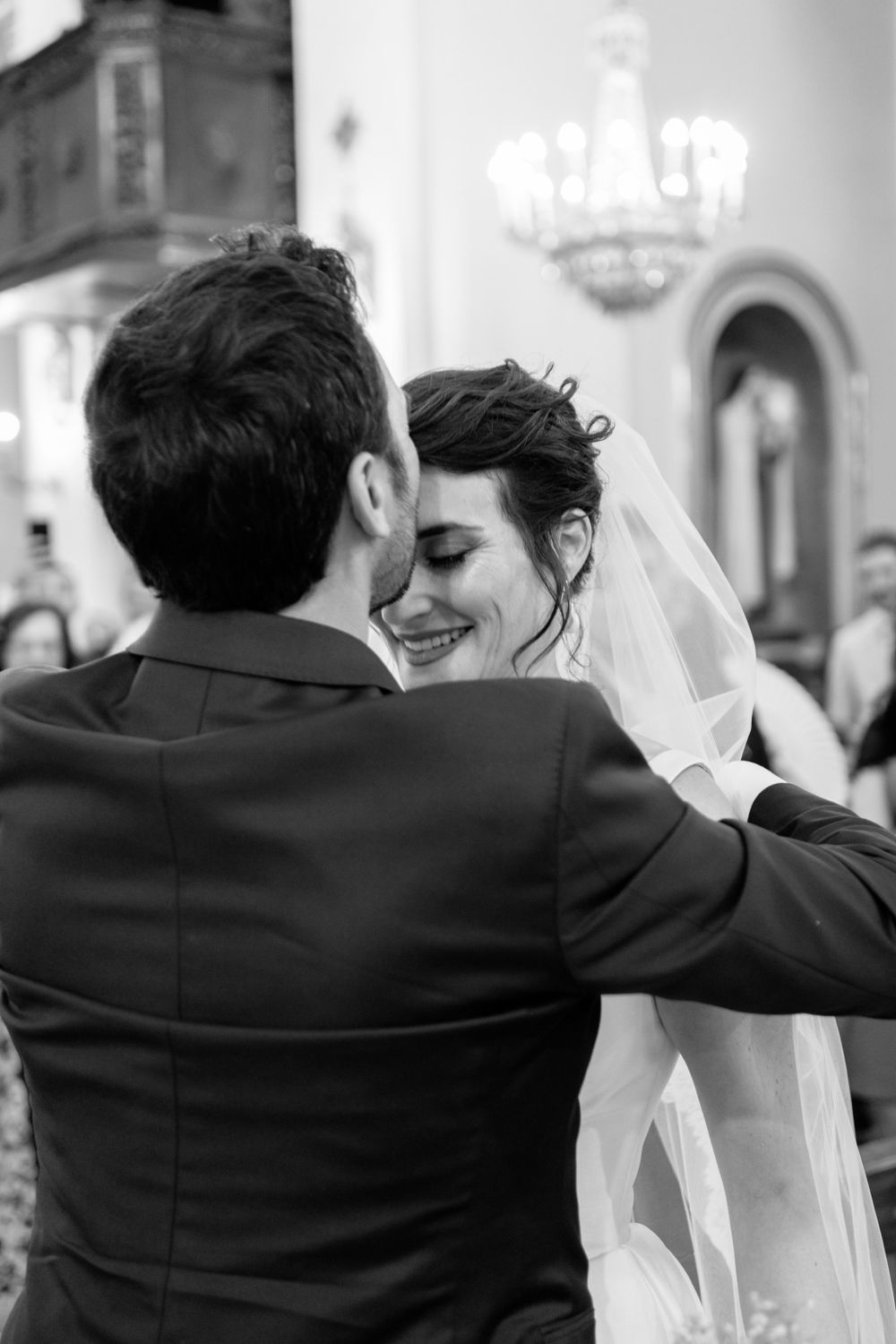 Black and white candid moment between newlyweds during their church ceremony.
